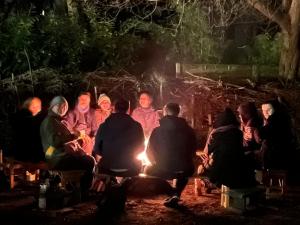Menschen sitzen ums Feuer